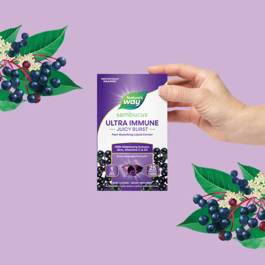 Nature's Way sambucus ultra immune product with hand holding it against a purple background with elderberry graphics.