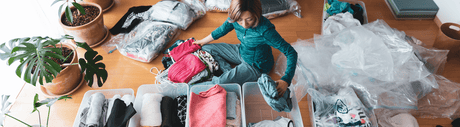 Woman sorting clothes into bins.