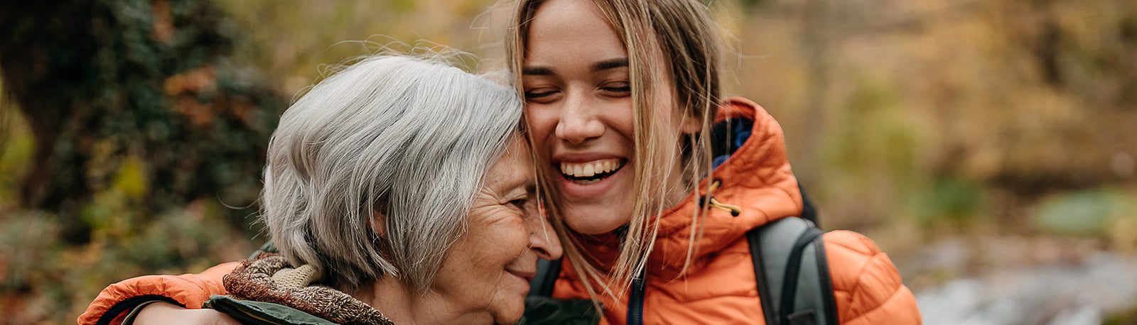 Young and old woman embracing.