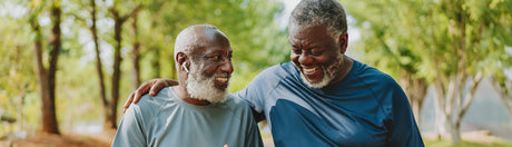 Two men on a walk smiling.