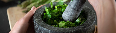 Cilantro in a mortar and pestle.