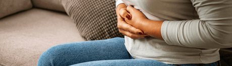 person holding their stomach as if it is bloated