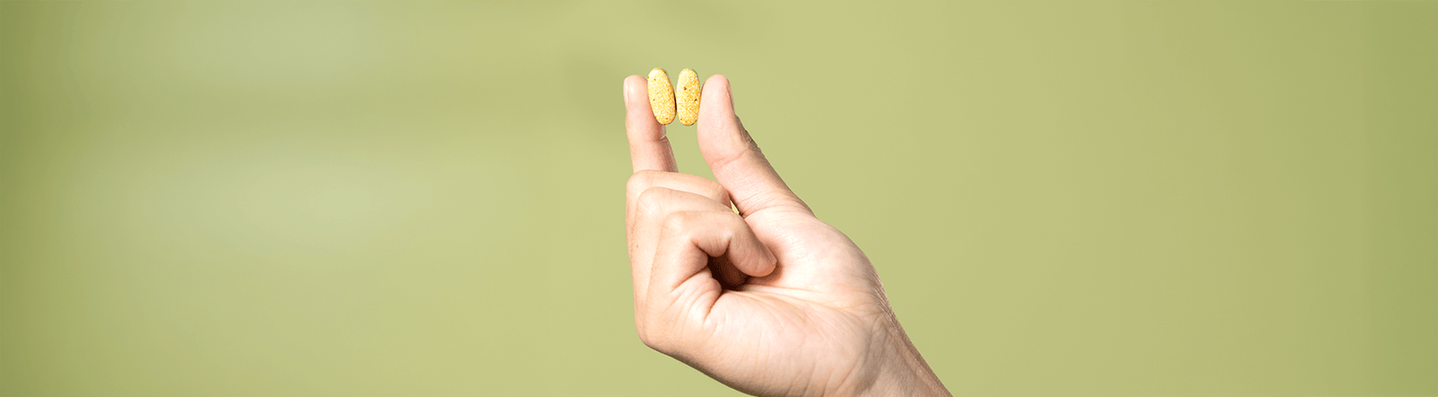 Hand holding two supplements.