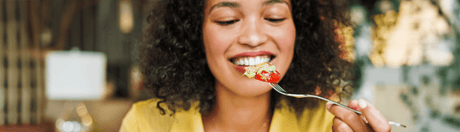Woman smiling and eating.