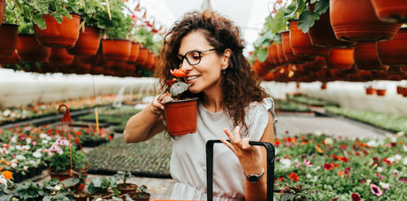 woman smelling flower at a greenhouse 