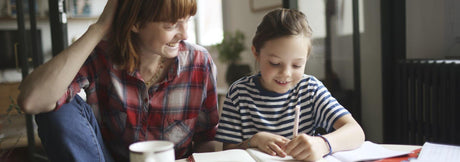 woman helping daughter with homework