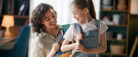 woman putting backpack on kid