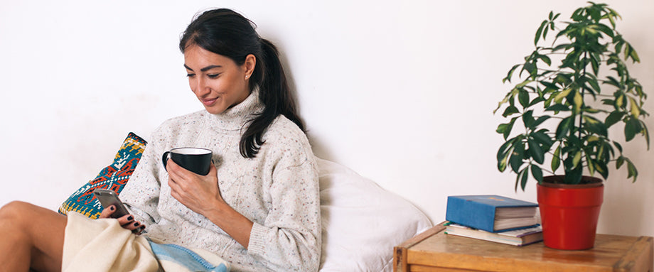 A woman browsing her phone and smiling.