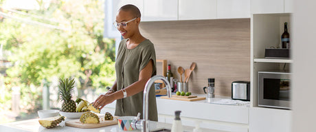 A woman cutting a pineapple.