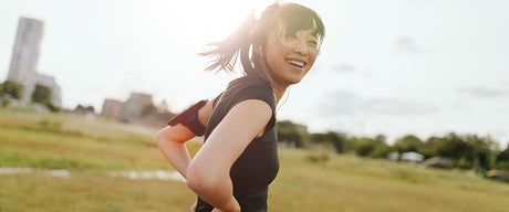 A woman standing outside with her hands on her hips.