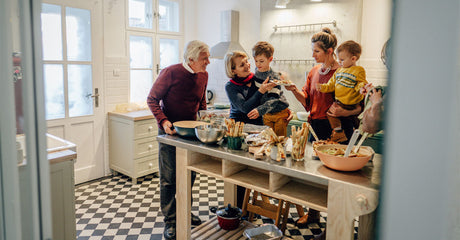A family preparing a holiday meal in a kitchen.