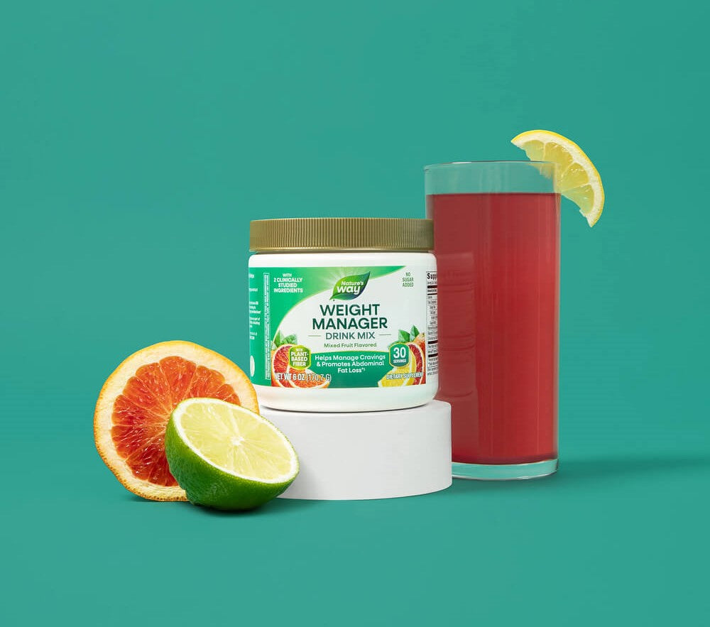 Weight Manager drink mix container with a glass of red juice and citrus fruits on a teal background