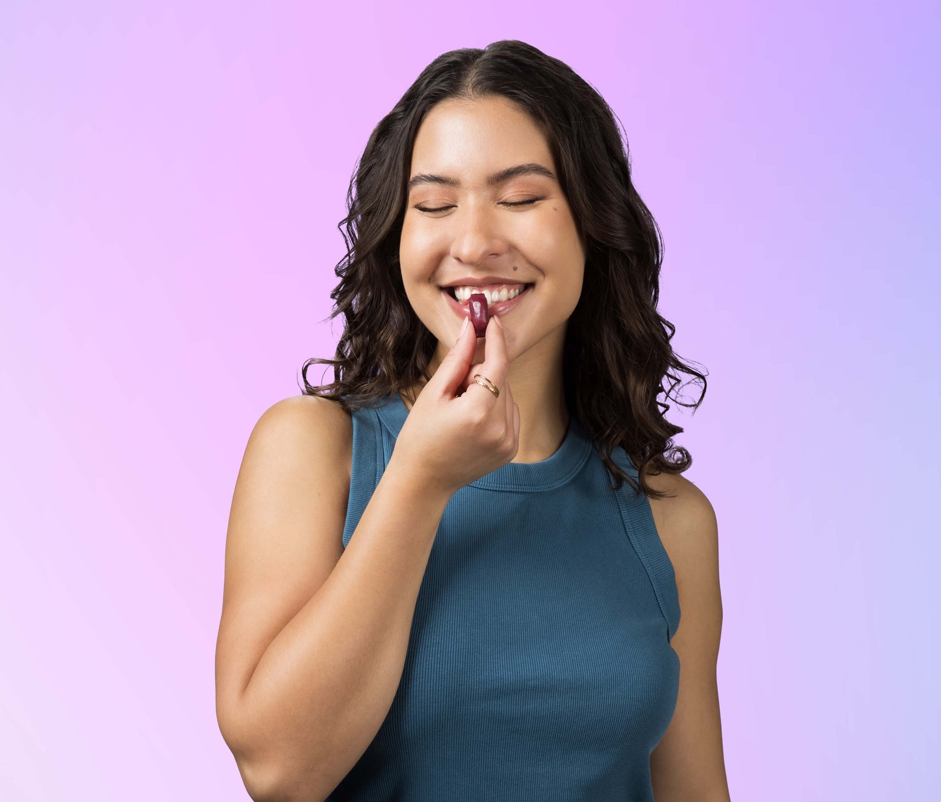 Woman putting Sambucus Ultra Immune Juicy Burst Chew into her mouth