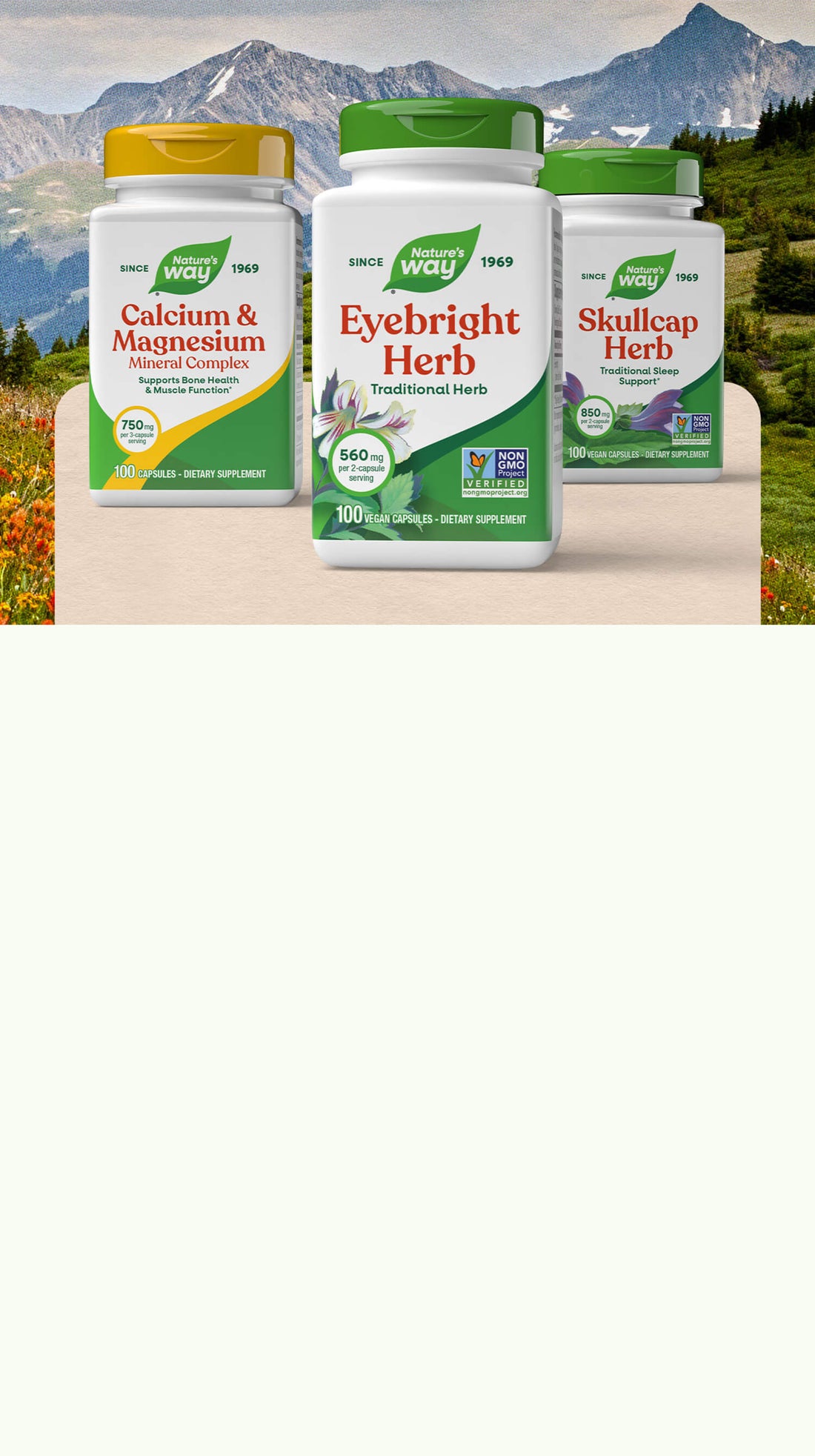 Three supplement bottles labeled 'Calcium & Magnesium', 'Eyebright Herb', and 'Skullcap Herb' on a wooden surface with a mountainous landscape in the background.