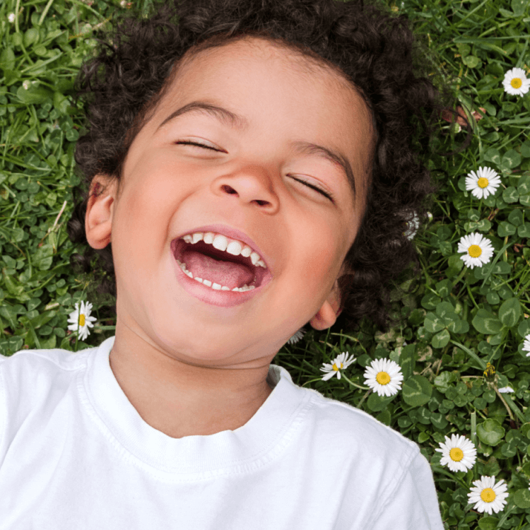 Boy smiling while lying in the grass