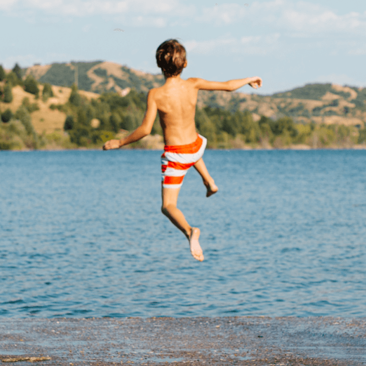 Boy jumping into the lake 