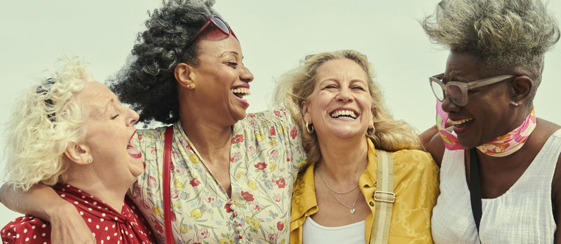 Four middle aged women laughing