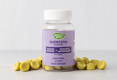 <{%DETAIL1_14327%}>A bottle of Nature's Way Quercetin Gummies 30 count surrounded by an array of gummies on a white surface