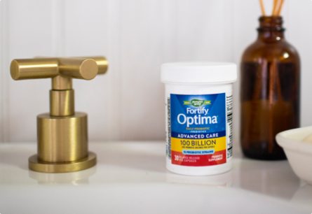 <{%DETAIL1_15784%}>A bottle of Fortify Optima Advanced Care probiotics sitting on a bathroom sink.