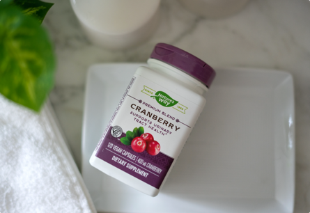 A bottle of Cranberry capsules laying on a white tray.